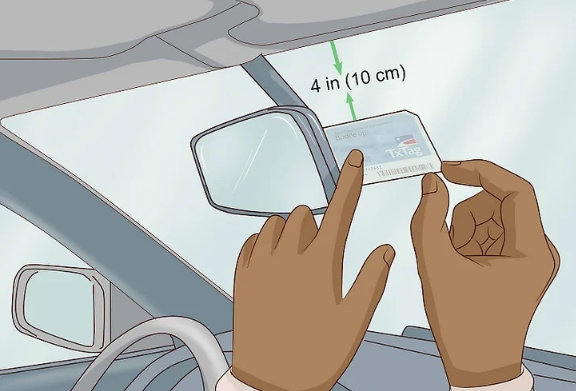 Coloque la etiqueta detrás del espejo retrovisor